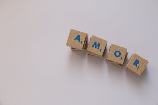 Wooden Scrabble tiles spelling 'Amor' on a white background, offering ample copy space.